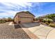 Desert landscaping with gravel and stone pavers accenting the exterior facade and driveway at 26057 W Sequoia Dr, Buckeye, AZ 85396