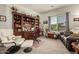 Well-lit office with a built-in desk, comfortable leather chairs, and serene view at 26057 W Sequoia Dr, Buckeye, AZ 85396
