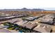 Expansive aerial view of a suburban neighborhood featuring houses with pools and mountain views in the distance at 26199 S 227Th St, Queen Creek, AZ 85142