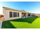 Expansive backyard with artificial turf, extended covered patio, and privacy landscaping at 26199 S 227Th St, Queen Creek, AZ 85142