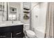 Bathroom with a white tub and shower combo, a black vanity and shelves with modern decor at 26199 S 227Th St, Queen Creek, AZ 85142