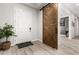 Inviting entryway featuring a white front door, wood-look tile flooring, and sliding barn door at 26199 S 227Th St, Queen Creek, AZ 85142