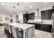 Modern kitchen with dark cabinetry, quartz countertops, stainless steel appliances, and island seating at 26199 S 227Th St, Queen Creek, AZ 85142