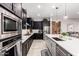 Modern kitchen featuring stainless steel appliances, black cabinetry, and an island with a sink at 26199 S 227Th St, Queen Creek, AZ 85142