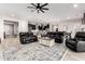 Open-concept living room with leather sofas, wood-look tile flooring, and seamless flow to the kitchen at 26199 S 227Th St, Queen Creek, AZ 85142