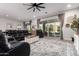 Spacious living room featuring a large leather sectional, ceiling fan, and sliding glass doors to patio at 26199 S 227Th St, Queen Creek, AZ 85142