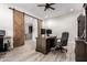 A home office showcasing wooden sliding barn doors and a sleek, functional desk setup at 26199 S 227Th St, Queen Creek, AZ 85142