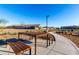 Picnic tables with wooden tops and modern black frames sit along the community walking path at 26199 S 227Th St, Queen Creek, AZ 85142
