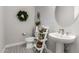 Chic powder room with a pedestal sink, decorative accents, and patterned tile flooring at 26199 S 227Th St, Queen Creek, AZ 85142