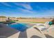 Beautiful backyard pool with lounge chairs, outdoor seating, and decorative string lights at 28883 N 131St Dr, Peoria, AZ 85383