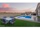 Attractive backyard pool with artificial turf, outdoor dining, and decorative string lights at 28883 N 131St Dr, Peoria, AZ 85383