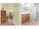 Bathroom with a double sink vanity with wood cabinets, mirror and adjoining bedroom at 28883 N 131St Dr, Peoria, AZ 85383