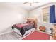 Bedroom featuring a ceiling fan, window with blinds, wood-look floors and Arizona Cardinal themed bedding at 28883 N 131St Dr, Peoria, AZ 85383