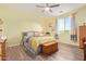 Bright bedroom features wood-look floors, a ceiling fan, and ample natural light at 28883 N 131St Dr, Peoria, AZ 85383