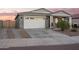View of home exterior featuring a spacious driveway and a two-car garage at 28883 N 131St Dr, Peoria, AZ 85383