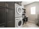 Organized laundry room featuring stacked washer and dryer units, built-in cabinetry, and a functional workspace at 34801 N 53Rd St # 29, Cave Creek, AZ 85331