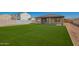 Large backyard features lush artificial grass, and a covered patio at 35 S Siena Ln, Casa Grande, AZ 85122