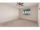 A bedroom featuring a ceiling fan, a large window, and neutral carpet at 35 S Siena Ln, Casa Grande, AZ 85122