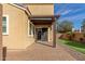 An outdoor patio with stone pavers, pergola, and a sliding glass door, overlooking artificial grass and palm trees at 3555 E Erie St, Gilbert, AZ 85295