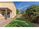 Beautiful backyard with artificial grass, stone pavers, tall trees, and a view of the home's exterior at 3555 E Erie St, Gilbert, AZ 85295