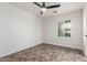 Well-lit bedroom with tile floors, a ceiling fan, and a window with plantation shutters at 3555 E Erie St, Gilbert, AZ 85295