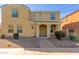 Tan two-story home with a covered porch entry, desert landscaping, and brick paver walkway at 3555 E Erie St, Gilbert, AZ 85295