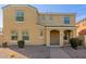Tan two-story home with a covered porch entry, desert landscaping, and brick paver walkway at 3555 E Erie St, Gilbert, AZ 85295