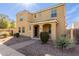 Tan two-story home with a covered porch entry, desert landscaping, and brick paver walkway at 3555 E Erie St, Gilbert, AZ 85295