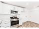 Bright kitchen with modern stainless steel appliances, white cabinets, and tiled floors at 3555 E Erie St, Gilbert, AZ 85295
