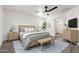 Bright main bedroom with sleek ceiling fan, stylish wood furniture, and plenty of natural light at 3555 E Erie St, Gilbert, AZ 85295