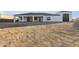 A modern home with a white exterior, dark roof, and covered patio in an undeveloped desert landscape at 36321 N 16Th St, Phoenix, AZ 85086