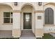 Covered front entry with pillars, arched entry, and dark green front door at 4020 E Toledo St # 103, Gilbert, AZ 85295