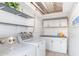 Bright laundry room with washer, dryer, storage cabinets, and floating shelves at 4245 N 16Th Dr, Phoenix, AZ 85015