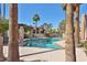 A pristine community pool surrounded by lush trees and landscaping, providing a serene and tropical atmosphere at 4434 E Camelback Rd # 132, Phoenix, AZ 85018