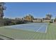 A well-maintained tennis court surrounded by mature trees and foliage, providing a scenic and private playing environment at 4434 E Camelback Rd # 132, Phoenix, AZ 85018