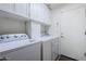 Functional laundry room featuring a washer, dryer, and ample cabinet space for storage at 6620 S Front Nine Dr, Gold Canyon, AZ 85118
