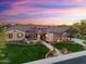 Stunning desert home with lush landscaping, stone details, and welcoming porch provides an inviting curb appeal at 7055 E Ivyglen Cir, Mesa, AZ 85207