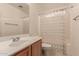 Bathroom featuring a sink vanity, large mirror, toilet and shower with patterned curtain at 7304 E Northridge Cir, Mesa, AZ 85207