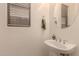 Stylish powder room featuring a pedestal sink, mirror, towel ring, and natural light from the window at 7304 E Northridge Cir, Mesa, AZ 85207