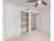 Bright bedroom featuring neutral carpet, a ceiling fan, and closet with built-in shelving at 7309 E Diamond Ave, Mesa, AZ 85208