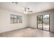 Spacious living room with tile floors, ceiling fan, and sliding glass doors leading to patio at 7309 E Diamond Ave, Mesa, AZ 85208