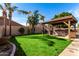 This backyard features a built-in outdoor kitchen, a well-maintained lawn and several trees and shrubs at 741 W Harvard Ave, Gilbert, AZ 85233