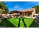 Lush backyard featuring a covered patio, outdoor kitchen, and landscaped lawn at 741 W Harvard Ave, Gilbert, AZ 85233