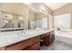 The bathroom features a double sink vanity with a soaking tub, shower and large mirror at 741 W Harvard Ave, Gilbert, AZ 85233