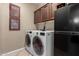 Convenient laundry room with washer, dryer, shelving and cabinet space with natural-colored walls at 741 W Harvard Ave, Gilbert, AZ 85233