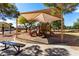 Community playground under a shaded canopy featuring slides, climbing structures, and a bench at 741 W Harvard Ave, Gilbert, AZ 85233