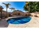 Backyard with a private pool surrounded by stone pavers, lush landscaping, and privacy fencing at 741 W Harvard Ave, Gilbert, AZ 85233