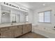 Bathroom with double sinks, large mirror, and a relaxing soaking tub at 811 N Los Feliz Dr, Chandler, AZ 85226