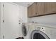 Laundry room with modern washer and dryer units and overhead cabinets at 811 N Los Feliz Dr, Chandler, AZ 85226
