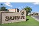Elegant Santa Fe community signage featuring a beige textured wall, brick accents, and lush landscaping at 8138 E Via De La Escuela --, Scottsdale, AZ 85258